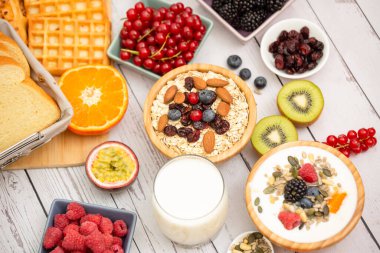 Kahvaltıda tereyağlı ekmek ve mısır gevreğiyle fincanda süt, çilek, yabanmersini, ahududu, kivi ve taze portakal ile servis edilir..