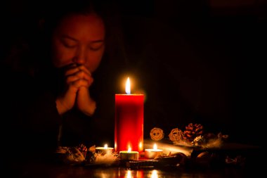 Tanrı 'ya dua eden ve ibadet eden bir kadın. Dini inançlarla el ele tutuşup Hıristiyanlığa tapan bir kadın. Kızıl Mum' la karanlığın karanlığında sönmüş ışıklara karşı.