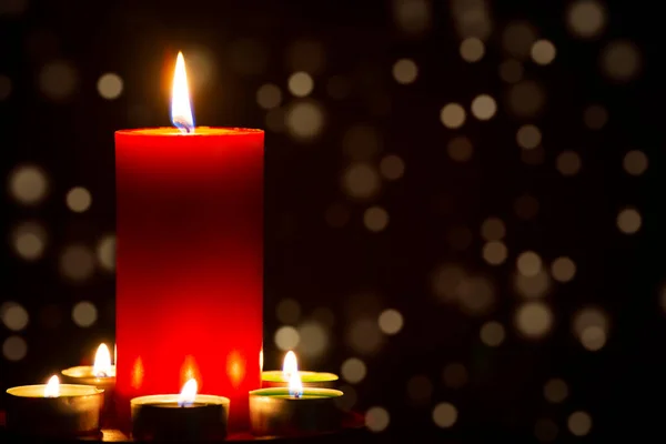 Czerwona Świeca Ogniem Przeciwko Rozproszonym Światłom Ciemności Złotym Bokeh Ciemnym — Zdjęcie stockowe