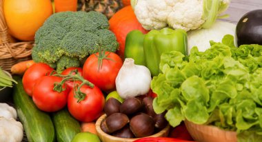 Sebzeler, elmalar, üzümler, portakallar ve muz ahşap sepette havuç, domates, guava, biber, patlıcan ve salata. Sağlıklı gıda kavramı.