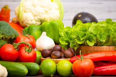 Sebzeler, elmalar, üzümler, portakallar ve muz ahşap sepette havuç, domates, guava, biber, patlıcan ve salata. Sağlıklı gıda kavramı.