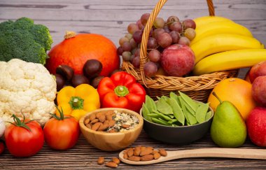 Sebzeler, elmalar, üzümler, portakallar ve muz ahşap sepette havuç, domates, guava, biber, patlıcan ve salata. Sağlıklı gıda kavramı.