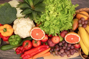 Sebzeler, elmalar, üzümler, portakallar ve muz ahşap sepette havuç, domates, guava, biber, patlıcan ve salata. Sağlıklı gıda kavramı.