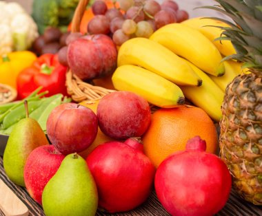 Sebzeler, elmalar, üzümler, portakallar ve muz ahşap sepette havuç, domates, guava, biber, patlıcan ve salata. Sağlıklı gıda kavramı.