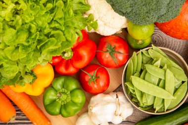 Sebzeler, elmalar, üzümler, portakallar ve muz ahşap sepette havuç, domates, guava, biber, patlıcan ve salata. Sağlıklı gıda kavramı.