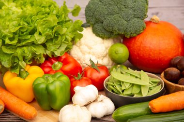 Sebzeler, elmalar, üzümler, portakallar ve muz ahşap sepette havuç, domates, guava, biber, patlıcan ve salata. Sağlıklı gıda kavramı.