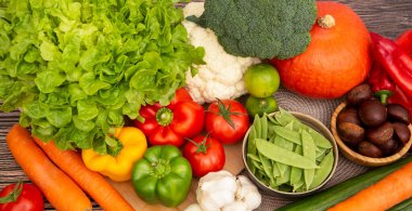 Sebzeler, elmalar, üzümler, portakallar ve muz ahşap sepette havuç, domates, guava, biber, patlıcan ve salata. Sağlıklı gıda kavramı.