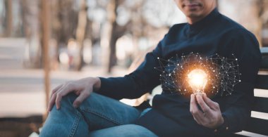 Parkta halat bağlantısı ve ikon işi olan bir adam el ele tutuşuyor, fikirleri ve yatırım bütçesini kurtarıyor, yaratıcı fikirler üretiyor, ev dışında çalışıyor.