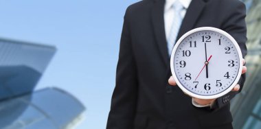 Zaman kazanma kavramı, iş adamı sabahın 6 'sında Beyaz arka planda bir saat tutuyor, evden çalışan çalışan, mesajınız için beyaz arka plan, normal zamanda çalışan.. 