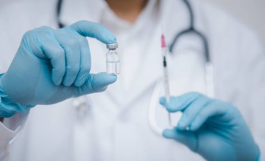 Steteskop taşıyan doktor veya bilim adamı COVID-19 aşısı, kızamık, koronavirüs aşısı salgın aşısı, aşı aşısı, virüs covid-19 korona virüsüne karşı mücadele kavramı