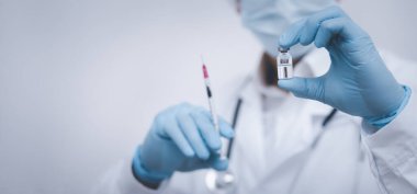 Steteskop taşıyan doktor veya bilim adamı COVID-19 aşısı, kızamık, koronavirüs aşısı salgın aşısı, aşı aşısı, virüs covid-19 korona virüsüne karşı mücadele kavramı