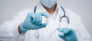 Steteskop taşıyan doktor veya bilim adamı COVID-19 aşısı, kızamık, koronavirüs aşısı salgın aşısı, aşı aşısı, virüs covid-19 korona virüsüne karşı mücadele kavramı