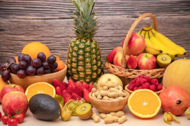 Grup meyveleri muz, portakal, çilek ve fındık karışımı, konsept sağlıklı gıda ve diyet, ahşap masanın en üst katında vejetaryen yiyecekler..