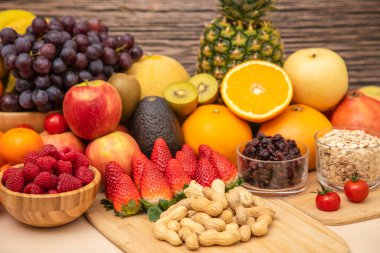 Grup meyveleri muz, portakal, çilek ve fındık karışımı, konsept sağlıklı gıda ve diyet, ahşap masanın en üst katında vejetaryen yiyecekler..