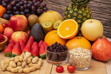 Grup meyveleri muz, portakal, çilek ve fındık karışımı, konsept sağlıklı gıda ve diyet, ahşap masanın en üst katında vejetaryen yiyecekler..