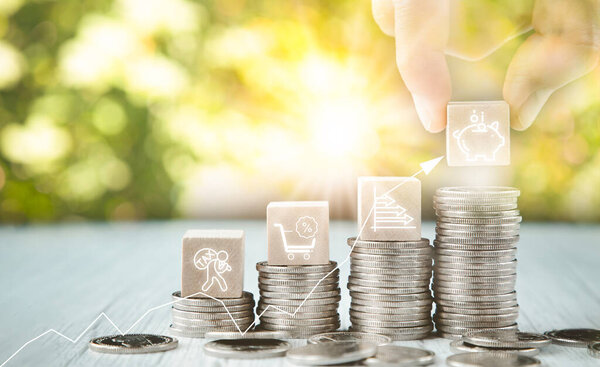 Close up of male hand stacking coins and Trees growing on coin in dark background ,Business Finance and Money, plant growing up on coins and investment budget, saving money investment.concept