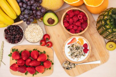 Grup meyveleri muz, portakal, çilek ve fındık karışımı, konsept sağlıklı gıda ve diyet, ahşap masanın en üst katında vejetaryen yiyecekler..