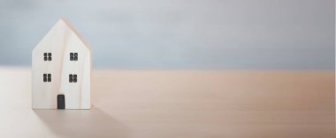 Mini ahşap ev modeli, ahşap masa, planlama, emlak almayı ve en iyisini seçmeyi planlama. Evden çalış ve ev konseptinde kal..