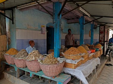 25 Haziran 2019 'da Basket' in önündeki dükkan sahibi Neral market Raigad Maharashtra INDIA 'da farklı türde kurutulmuş balık dükkanıyla hizaya girdi.