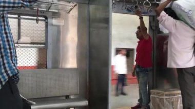 Porter, yerel Tain Kurla 'nın bavul bölümünde mal taşıyor.