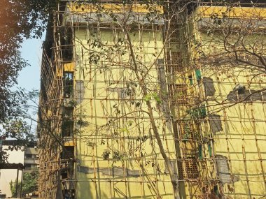 14 Şubat 2021, Bambu iskelesi 25 yaşındaki dört katlı bina kapısı Lokgram Kalyan Maharashtra Hindistan 'da yapısal onarım çalışmaları yapılıyor.