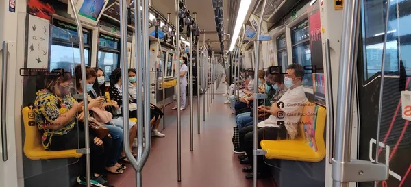 Bangkok-Tayland-09 Mart 2021: BTS trenindeki yolcular kendilerini Covid-19 'dan korumak için maske takarlar..
