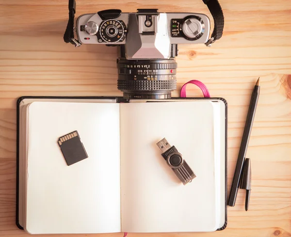 Retro vintage eski fotoğraf makinesi ile defter, kalem, pendrive, sd