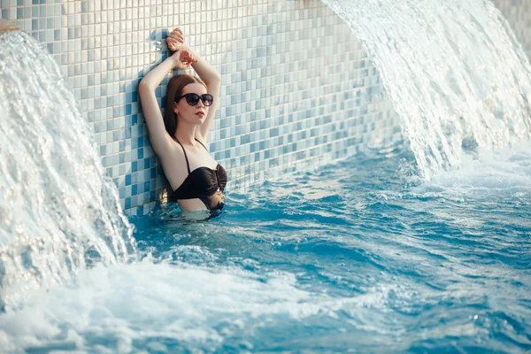 Retrato de una hermosa mujer en una piscina. hermoso largo — Foto de Stock