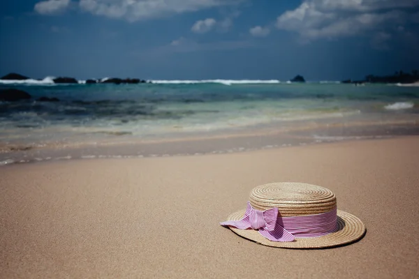 Straw hat on a tropical beach — Stock Photo, Image