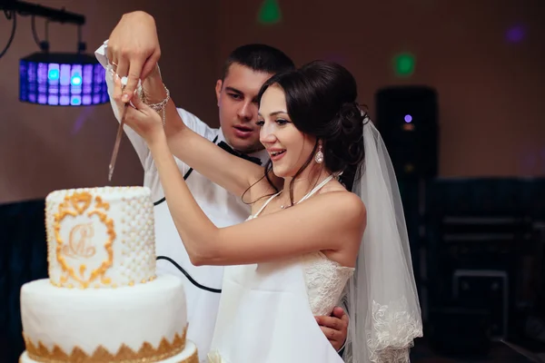 Noiva feliz e noivo cortar o bolo de casamento — Fotografia de Stock