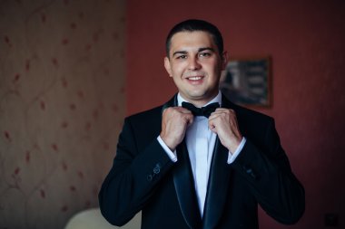 Damat bir kravat ve gülümsüyor tutar. Portre damadın üzerinde onların 