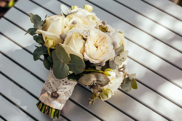 Hochzeitsstrauß aus weißen Rosen und Pfingstrosen auf dem Tisch liegend — Stockfoto