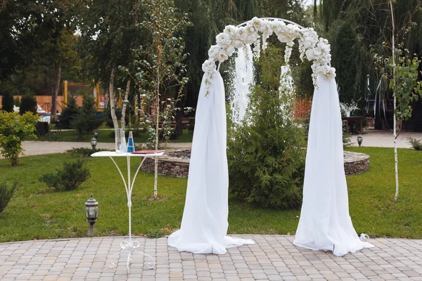 De ceremonie van het huwelijk in een prachtige tuin/huwelijksboog — Stockfoto