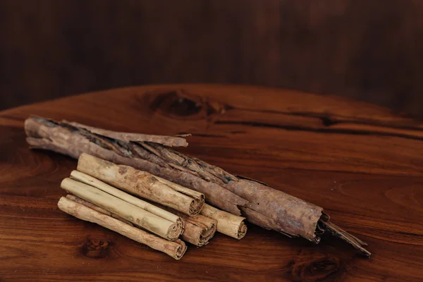Sekumpulan tongkat kayu manis di meja kayu — Stok Foto