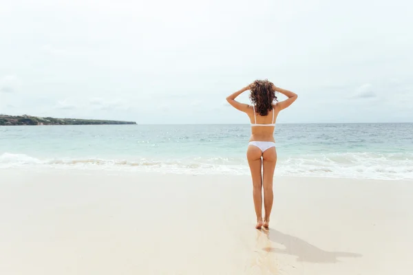 Vacker flicka i baddräkt promenader längs vyn beach.back — Stockfoto