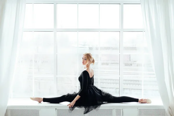Балерина робить розкол на танцювальному класі балету біля вікна — стокове фото