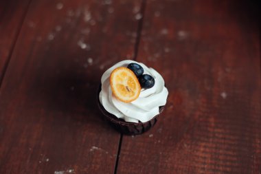 Kamkat meyveleri ve yaban mersini Tepesi üzerinde wo vanila cupcakes