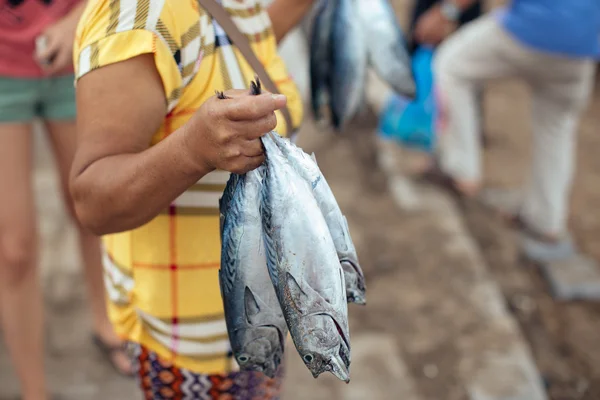 Man holding fresh fish by their tails on the fish market in Bali — Stock Photo, Image