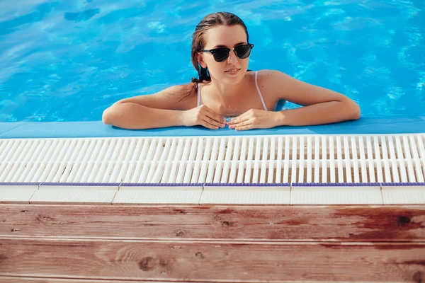 Tanned beautiful brunette woman in white bikini and sunlasses si — Stock Photo, Image