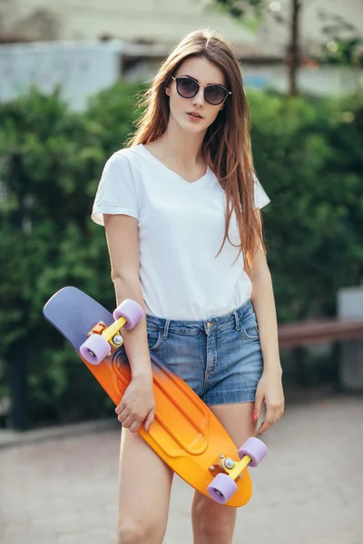 Sport fashion brunette girl in denim shorts, posing in summer wi — Stock Photo, Image