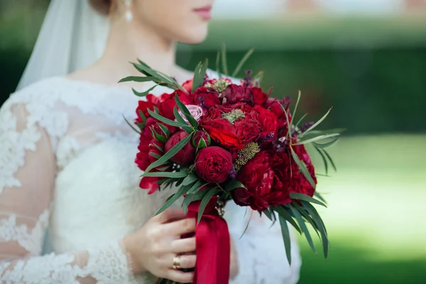 Matrimonio. La ragazza in un abito bianco in piedi su sfondo verde — Foto Stock