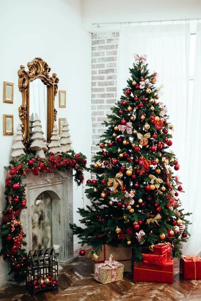 Natal e Ano Novo decorado quarto interior com presentes e árvore de Ano Novo perto de fogo lugar em estilo clássico vermelho — Fotografia de Stock