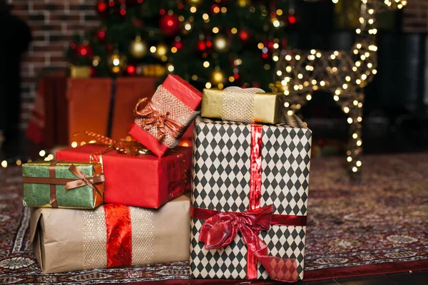 Noel hediyesi kutusu. Yılbaşı hediyeleri kırmızı ve kahverengi kutularda Noel ağacı arka planında tavan arası fotokopi alanında. — Stok fotoğraf