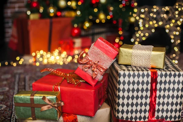 Stäng julklappslådan. Julklappar i röda och bruna lådor på julgran bakgrund i loft interiör kopia utrymme. — Stockfoto