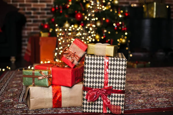 Çatı katında kahverengi ve kırmızı kağıda sarılı Noel hediyeleri. Arka planda ise bulanık Noel ağacı lekeleri var. Boşluğu kopyala — Stok fotoğraf
