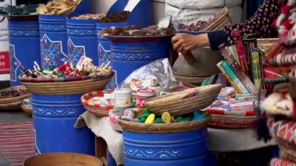 Marocko, Marrakech - oktober 2019: Traditionell produktion av arganolja, Marocko. Närbild hand berber kvinna producerar jordnöt pasta spricka med sten verktyg utanför på gatumarknaden — Stockvideo