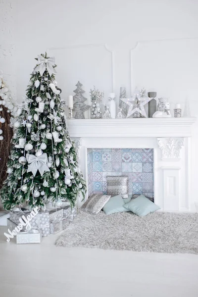 Christmas and New Year decorated white interior room with presents and New year tree and fireplace — Stock Photo, Image