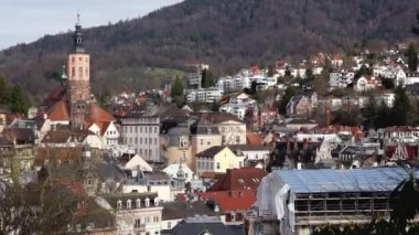 Baden-Baden şehrinin panoramik manzarası. Güneşli baharda, dağlar arasında kiremitli çatıları olan binalar. Baden-Wurttemberg, Almanya