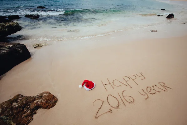 Happy 2016 year  written in sand with santa hat — Stock Photo, Image