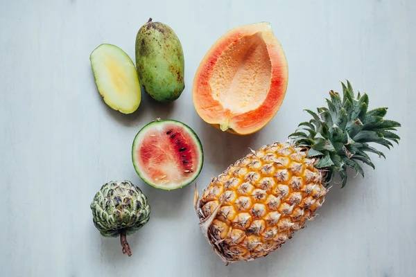 Εξωτικά φρούτα ποικιλία στο λευκό τραπέζι. Φέτες φρέσκα φρούτα σε καρτέλα — Φωτογραφία Αρχείου